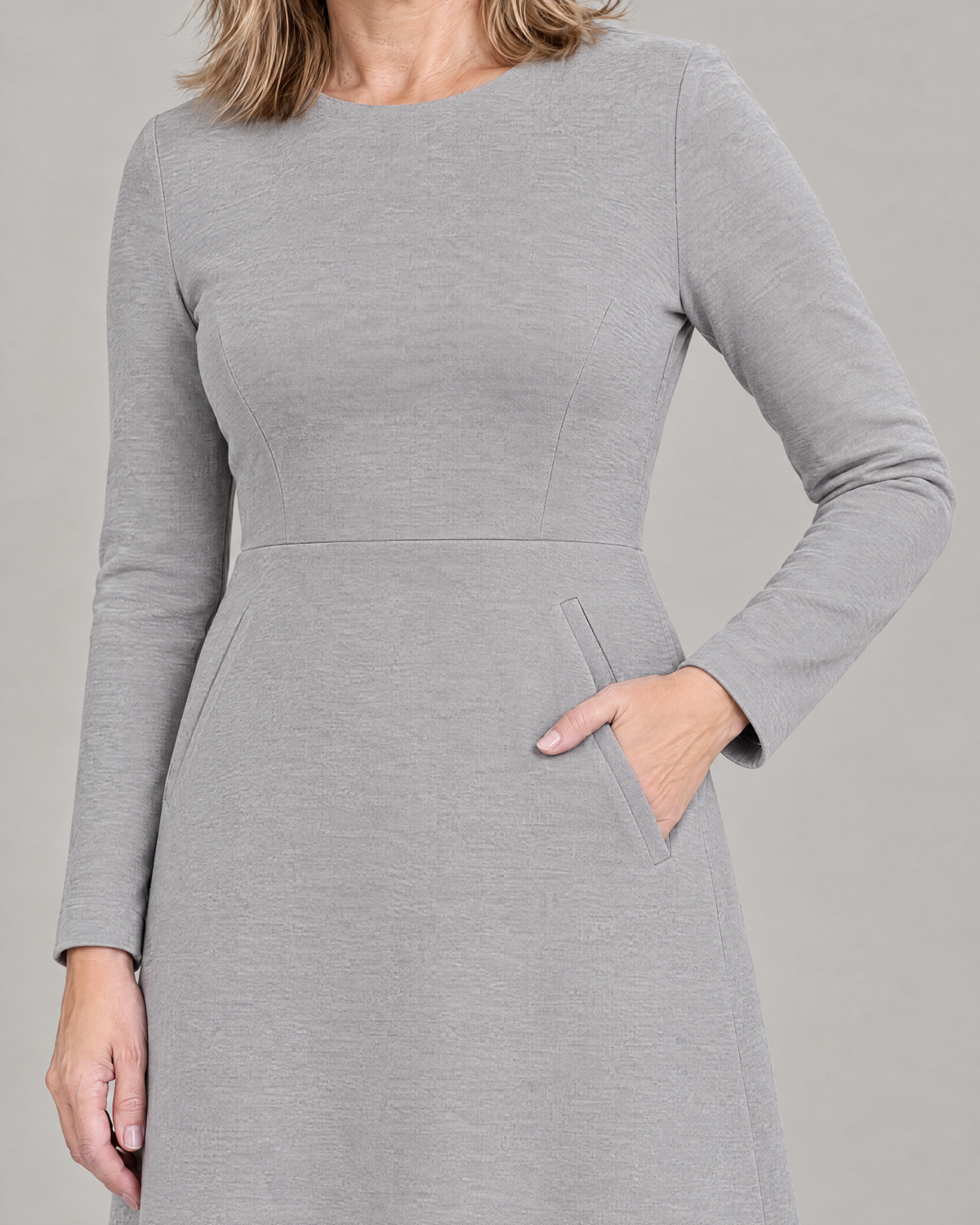 Close-up of the GLIDE slanted welt pocket at the waist seam, light grey wool knit
