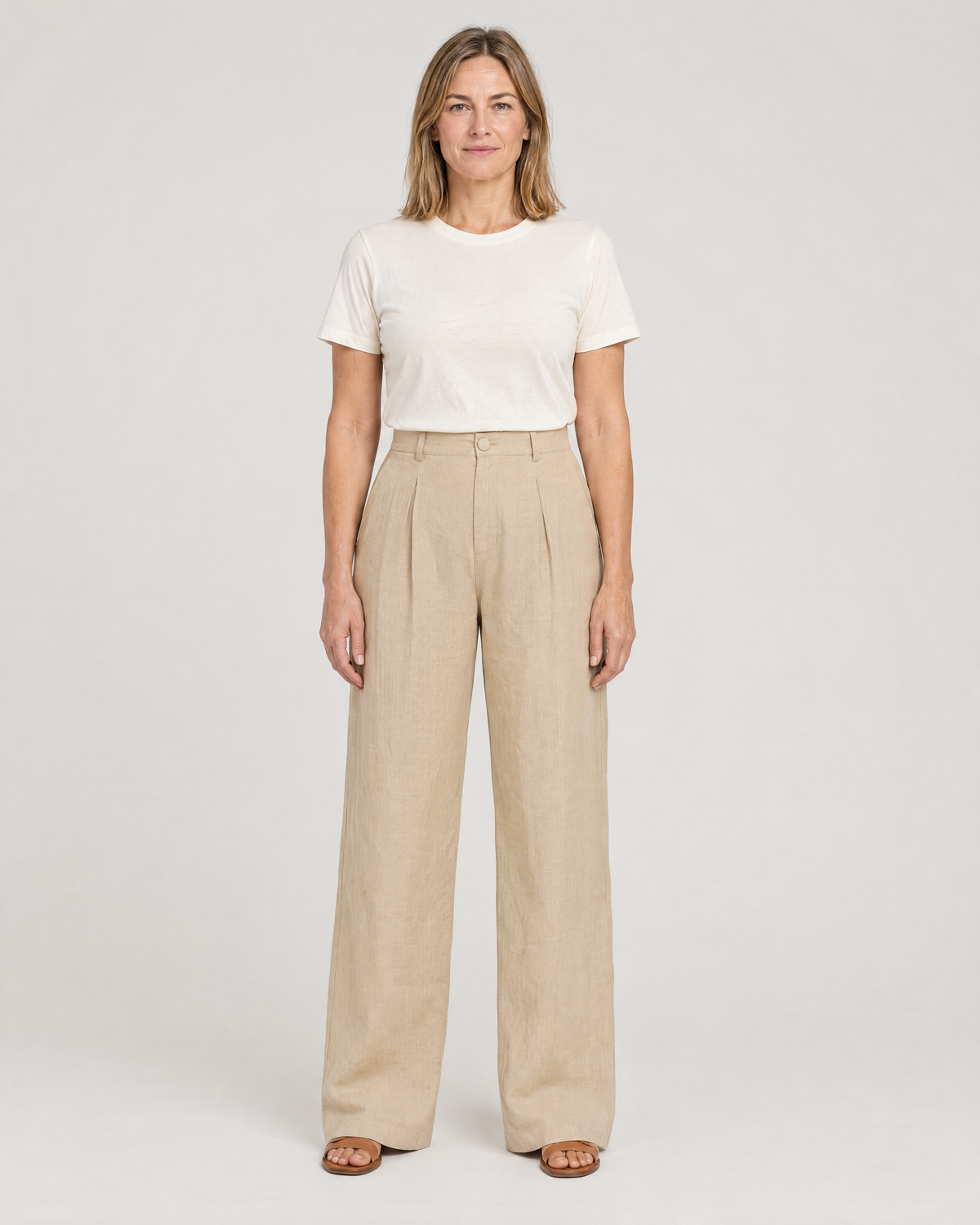 LYRA OPAQUE beige linen high-waisted pleated wide-leg trousers with a tucked-in white T-shirt, front view