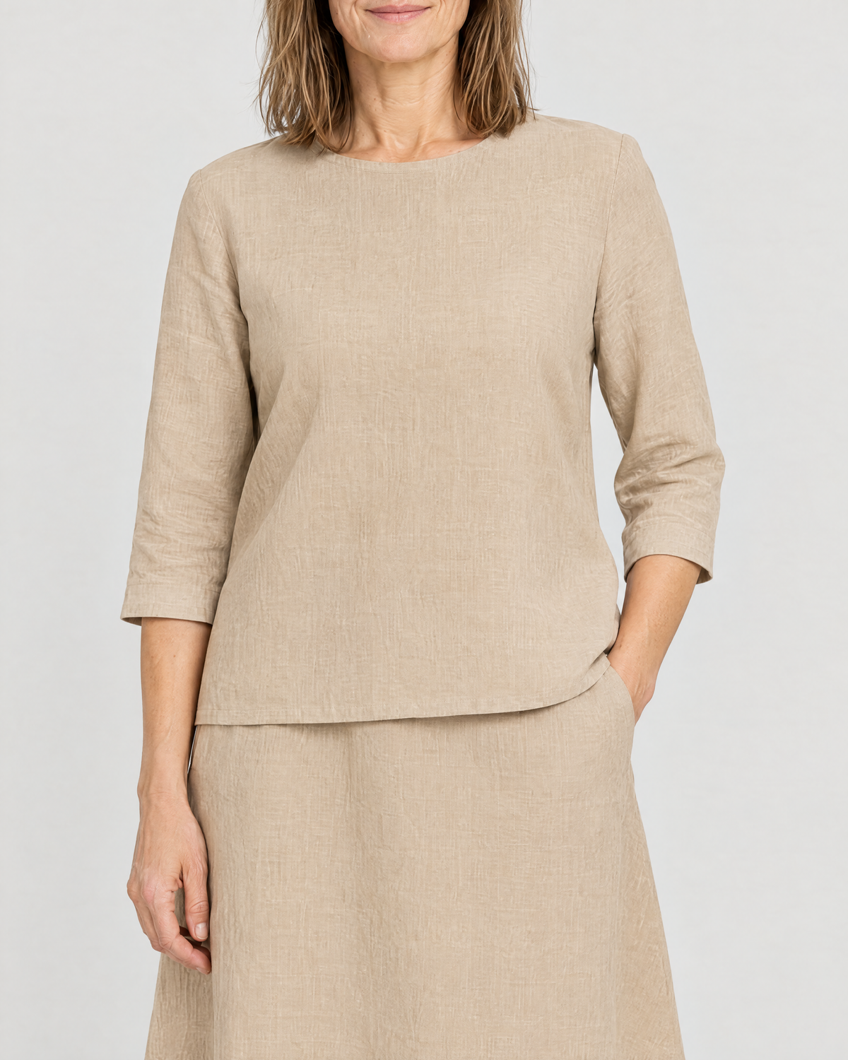 Close-up of the PAIR high round neckline, three-quarter sleeve and skirt side pocket in beige linen