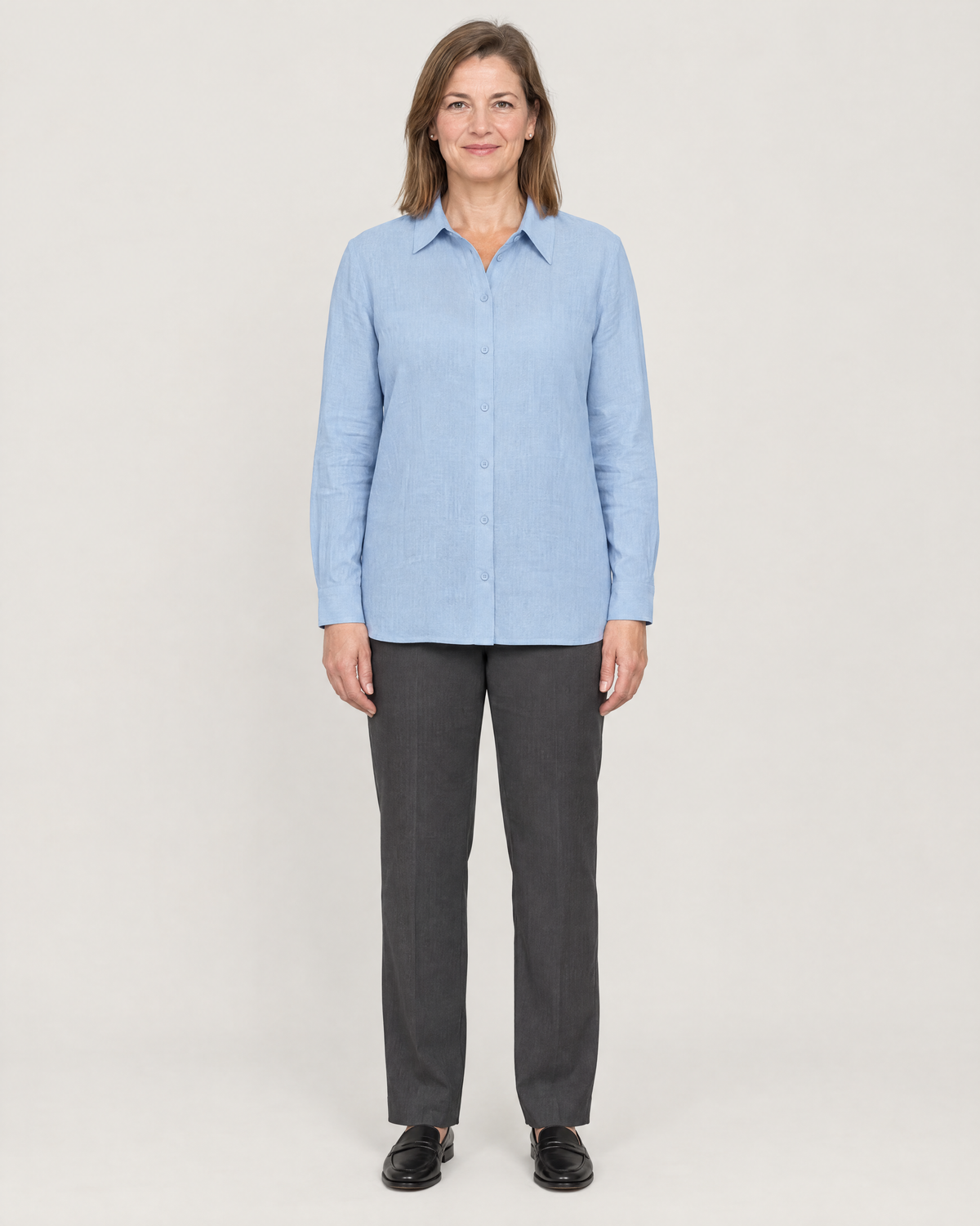 SOFT SHIRT light blue linen long-sleeve button-front shirt with an asymmetric collar, worn untucked with charcoal trousers, front view