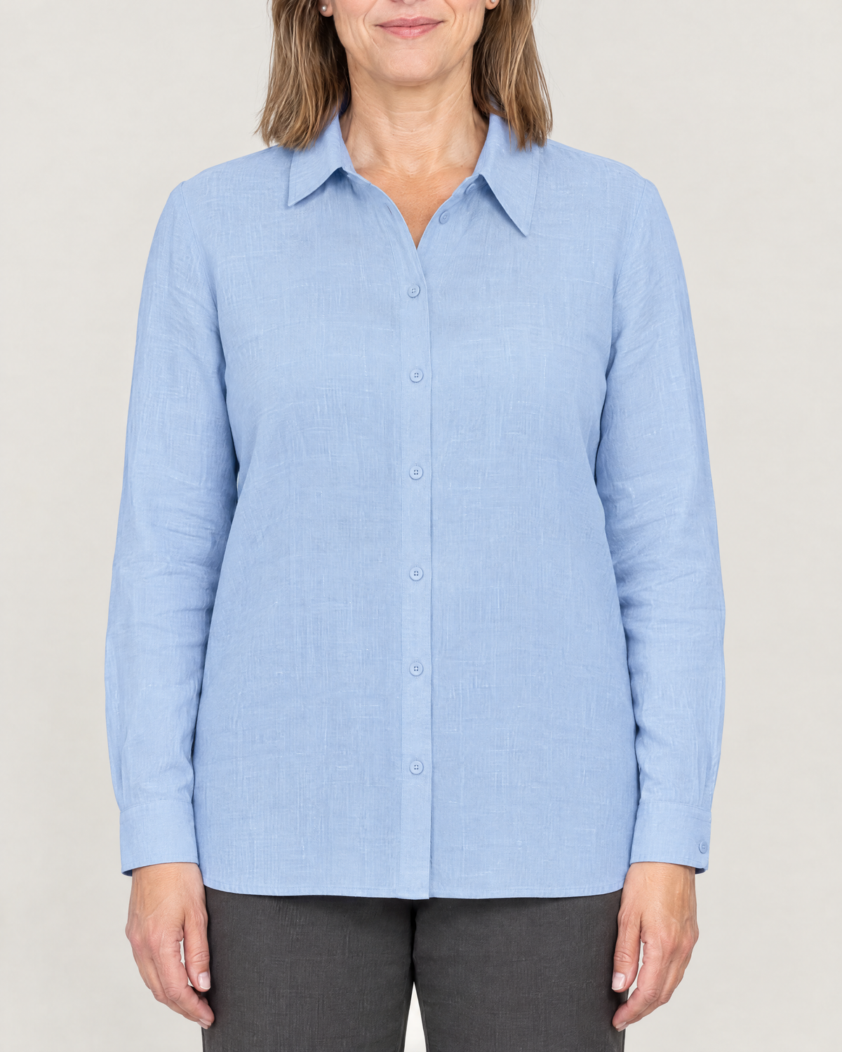 Close-up of the SOFT SHIRT asymmetric collar and flat button placket in light blue linen