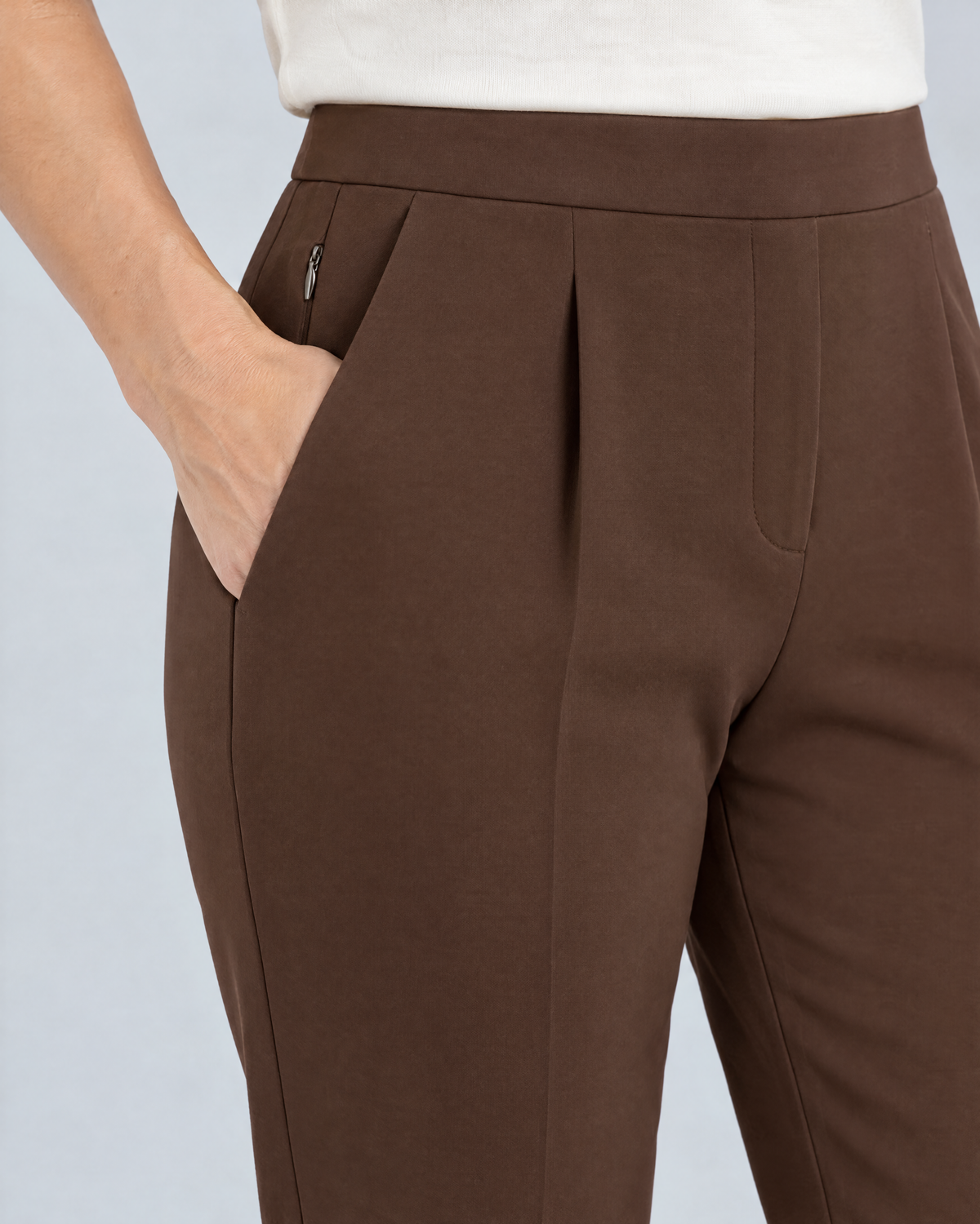 Close-up of the SIT WELL flat waistband, shallow pleat, slanted pocket and concealed fly in brown Punto Milano