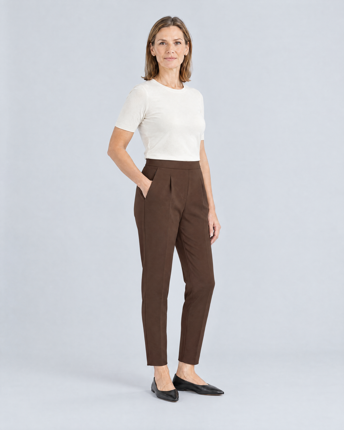 SIT WELL brown trousers, three-quarter view with hand in the slanted front pocket