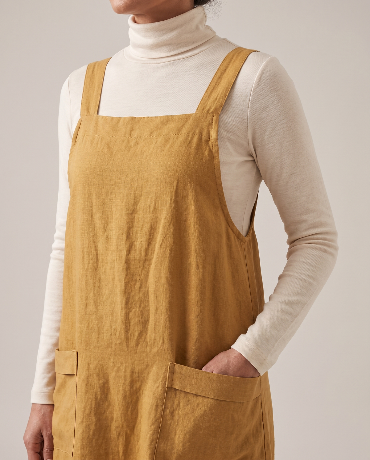 LAYER linen pinafore dress in Ochre, neckline and pocket detail