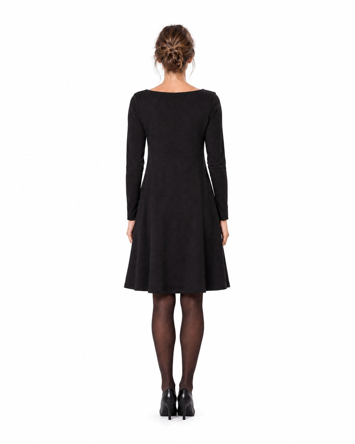 A woman modeling a black long-sleeve A-line dress with a boat neckline, seen from behind showing the back and A-line skirt. #Color_Black