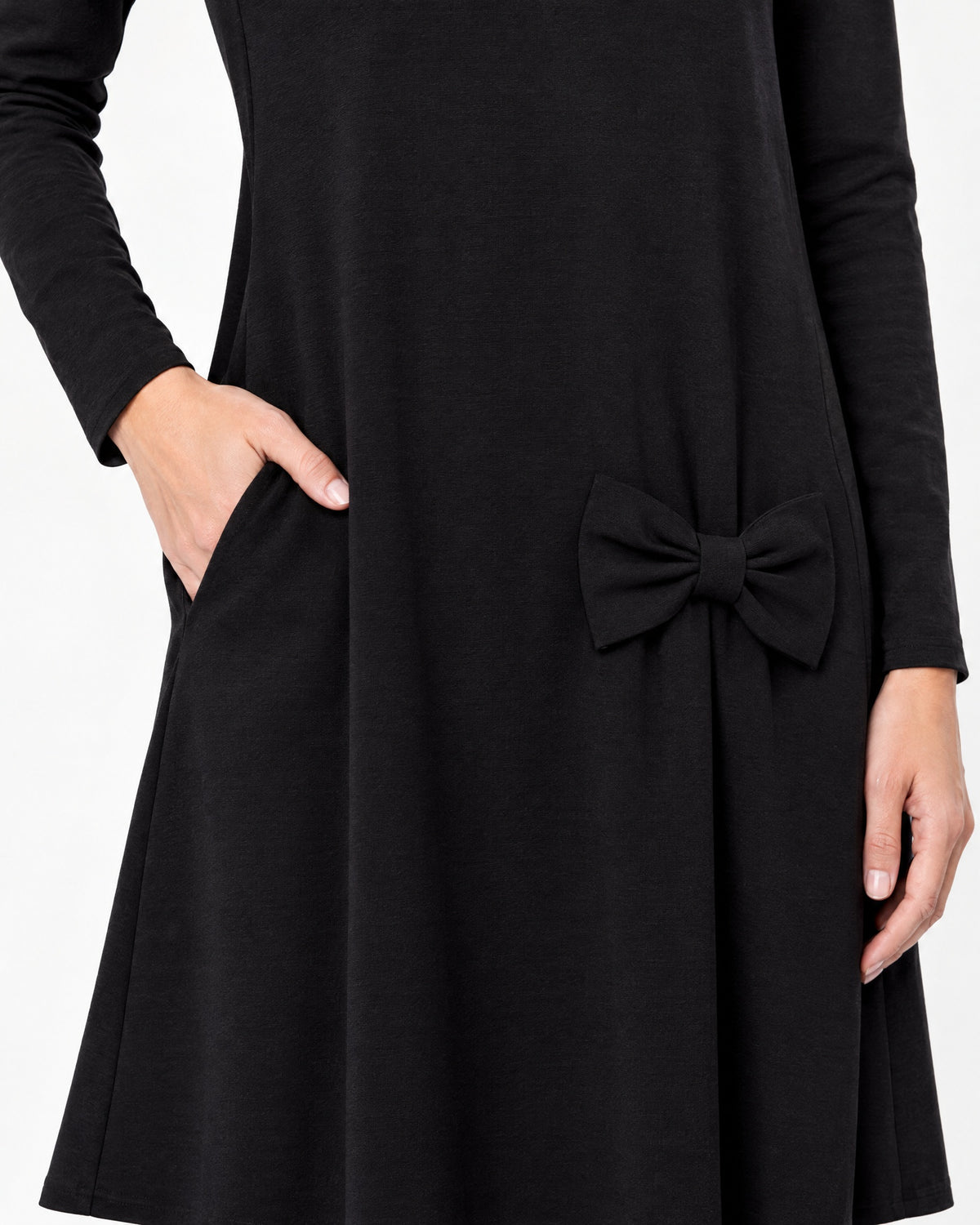 Close-up of a black long-sleeve A-line dress showing the side pocket, bow detail and Punto Milano knit fabric texture. #Color_Black