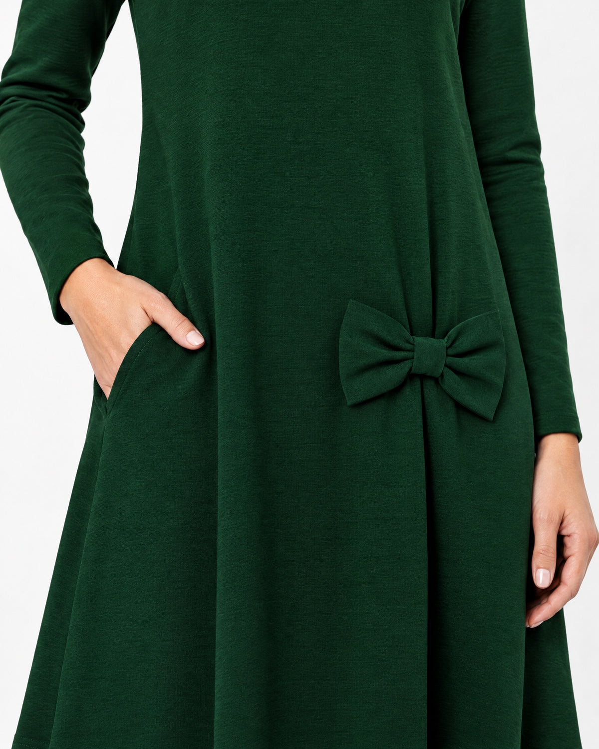 Close-up of a dark green long-sleeve A-line dress showing the side pocket, bow detail and Punto Milano knit fabric texture. #Color_Green