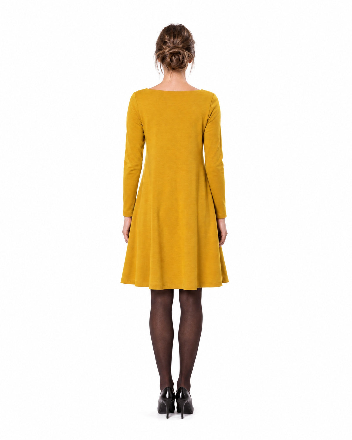 A woman modeling a mustard yellow long-sleeve A-line dress with a boat neckline, seen from behind showing the back and A-line skirt. #Color_Yellow