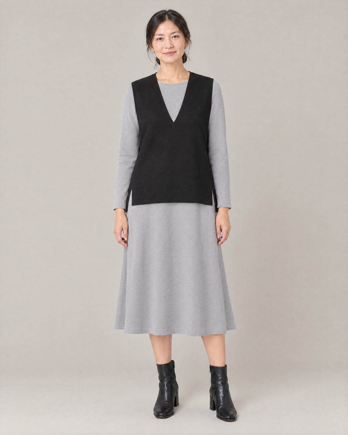 LIGHT VEST in black fine wool worn over a light grey midi dress, front view