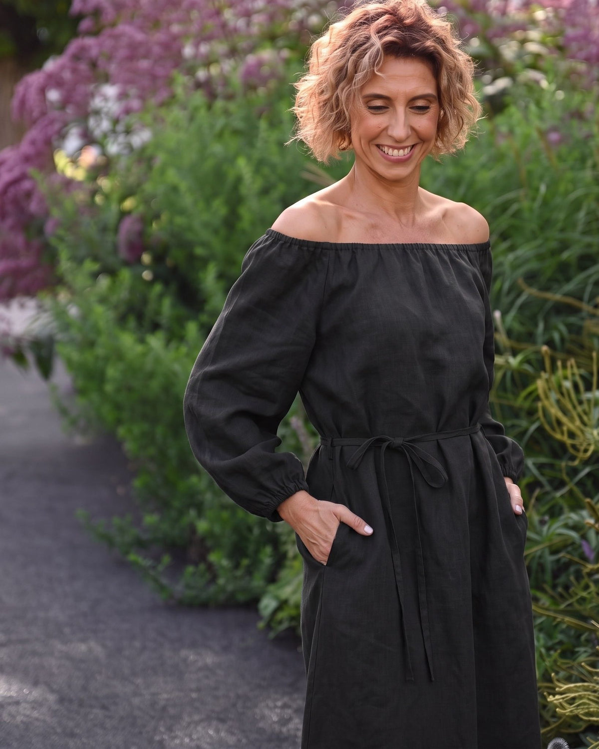 MOON – Black off-shoulder linen midi dress, lifestyle in a garden #Color_Black