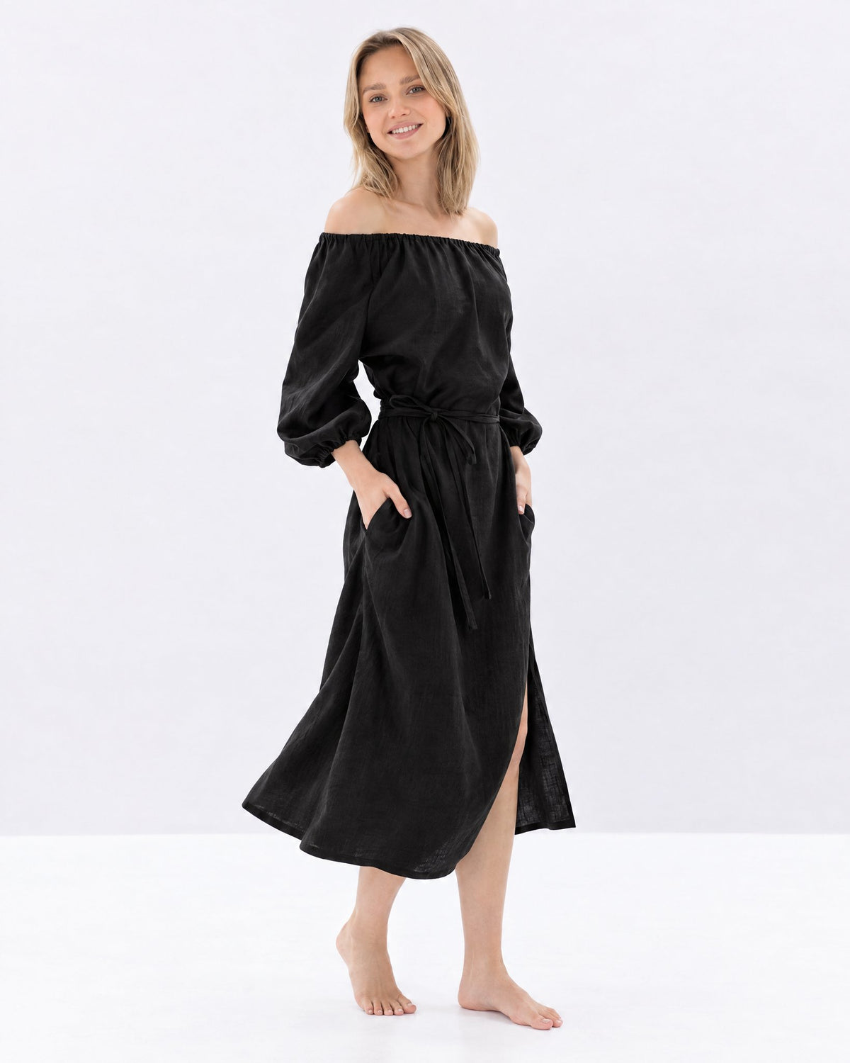 MOON – Black off-shoulder linen midi dress, side view walking in studio #Color_Black