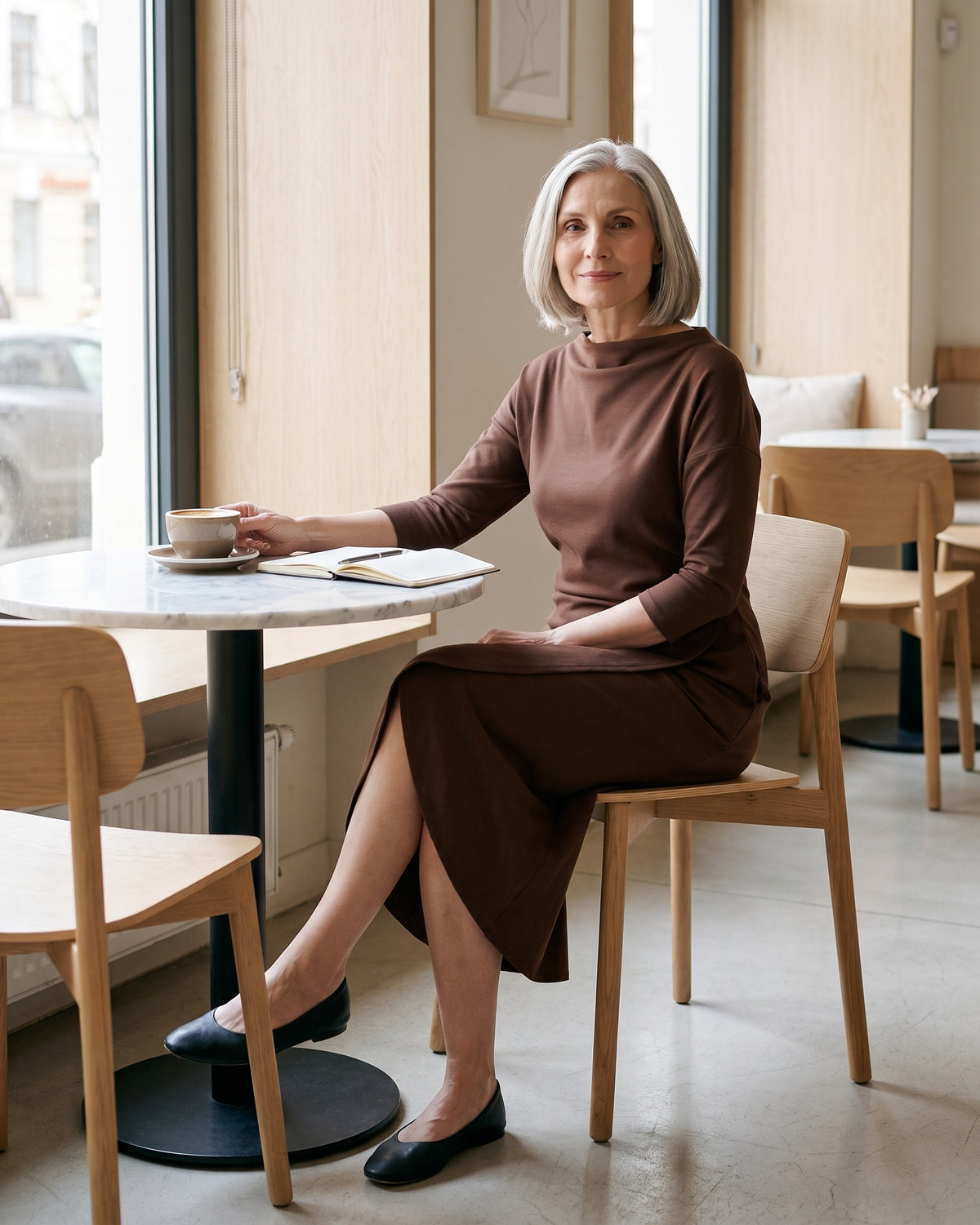 SELMA midi dress in Brown, seated in a cafe, tulip skirt stays closed