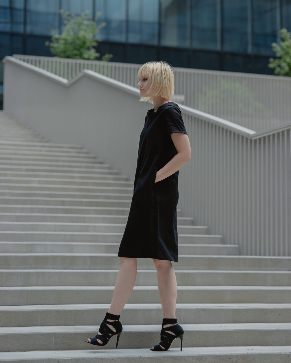 LeMuse STORY linen dress in black – side view full length on stairs #Color_Black