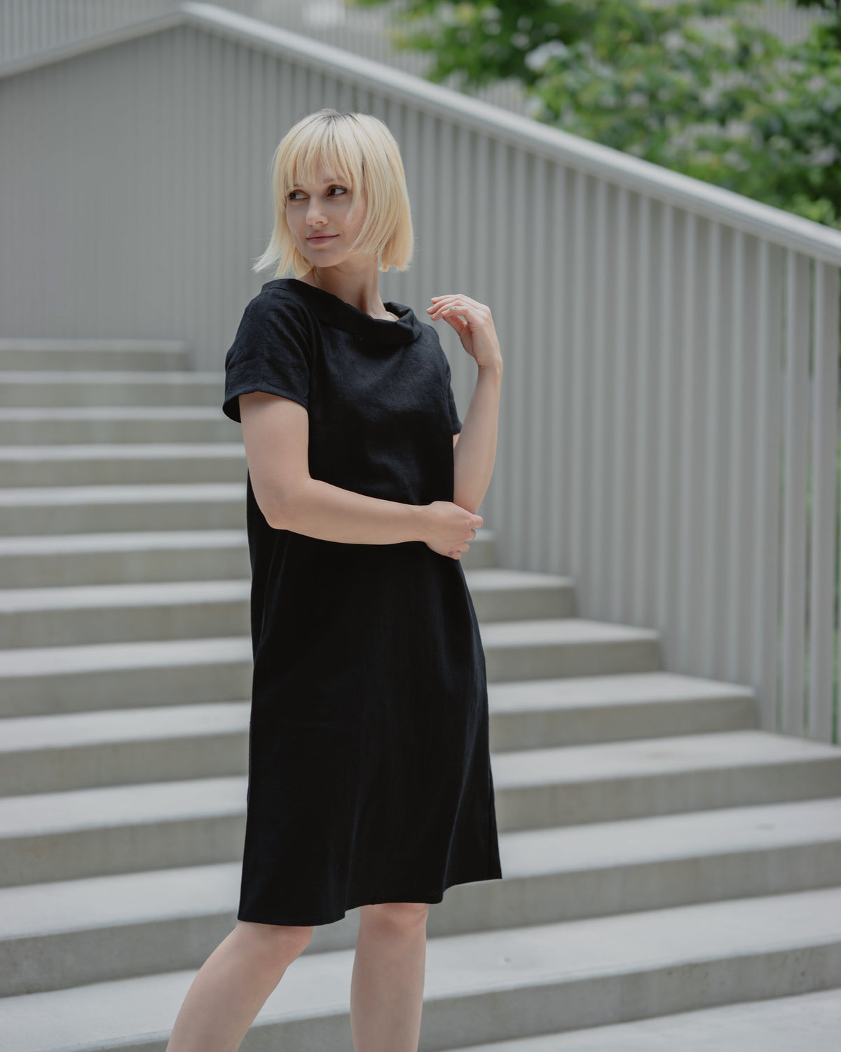 LeMuse STORY linen dress in black – three-quarter front view on stairs #Color_Black