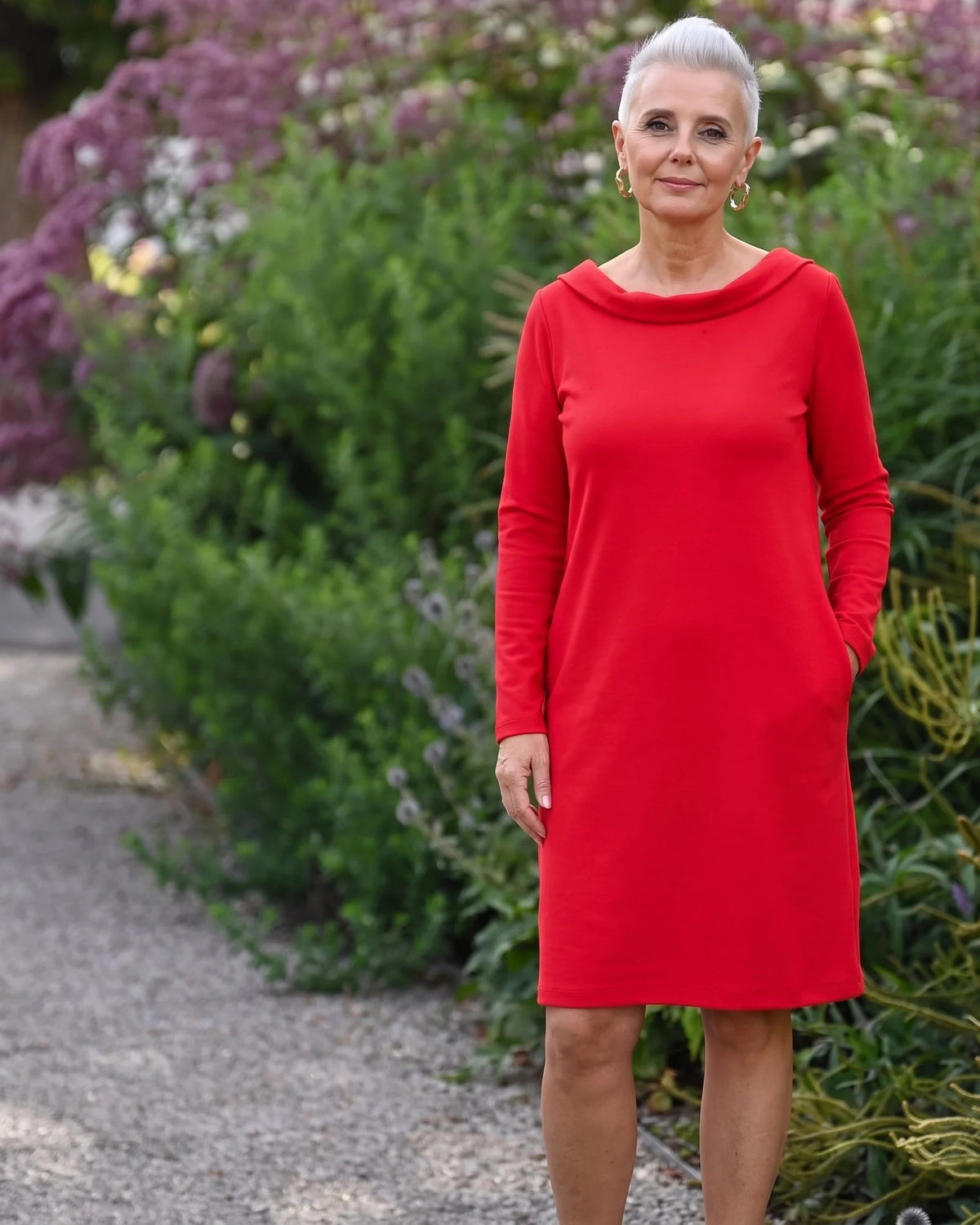 STORY Punto Milano – red dress worn on a garden path #Color_Red