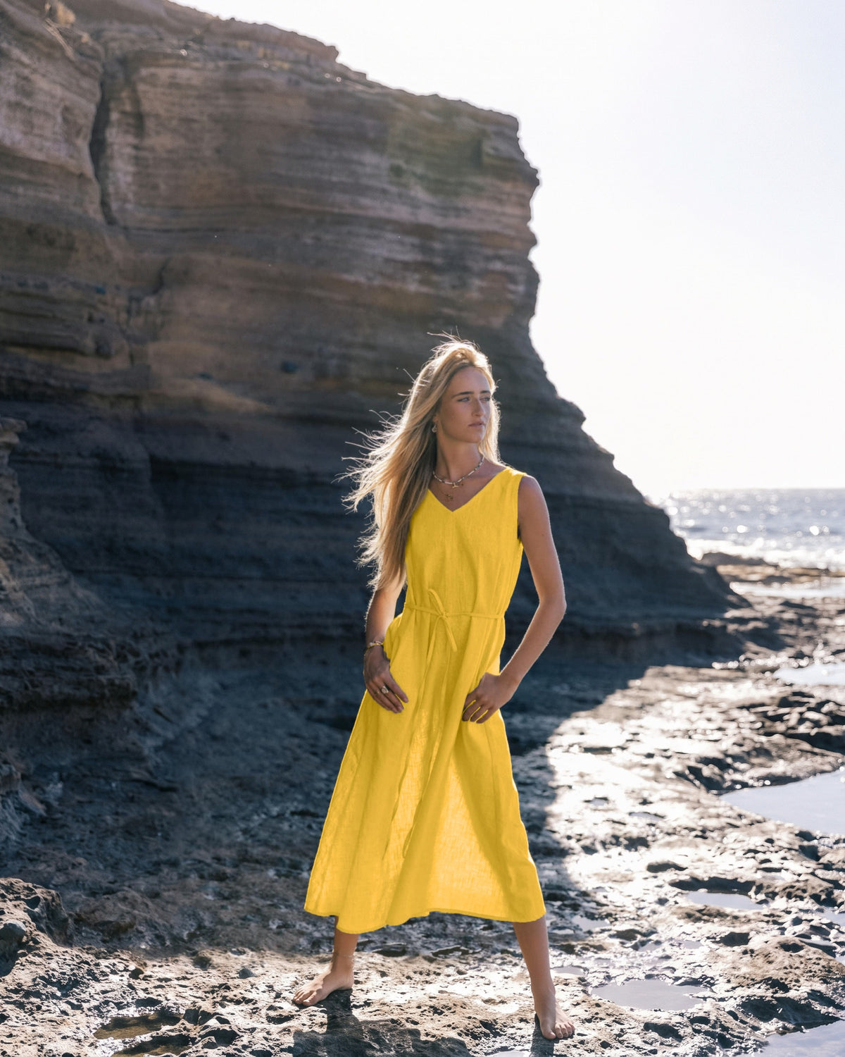 Robe en lin LeMuse SUNSET, coloris jaune – mannequin de face en pied près des falaises