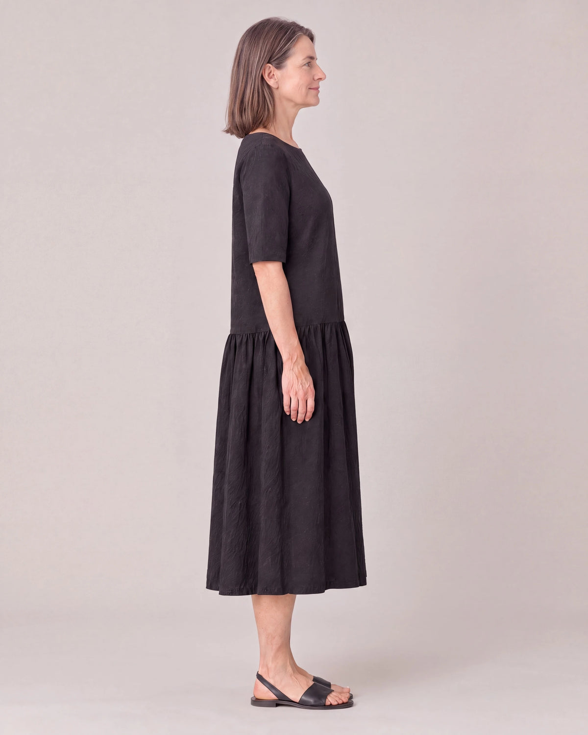 TESSA black linen tiered midi dress, side view with elbow-length sleeve