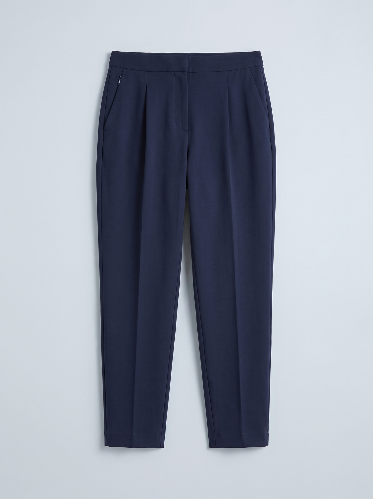 TRAVEL ink navy tapered trousers arranged flat to show the full silhouette